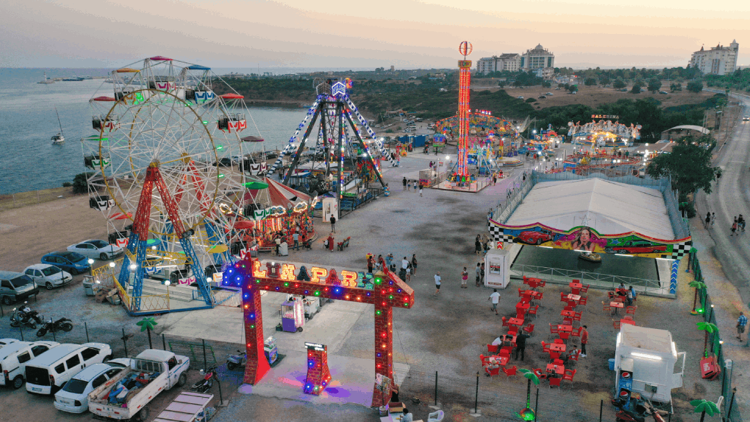 Gün batımında lunapark ve deniz manzarası